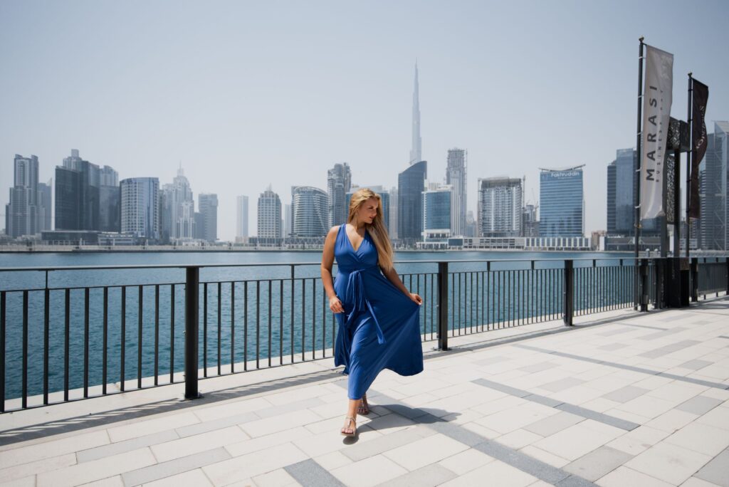 Kobieta w niebieskiej sukni na tle panoramy Dubaju
