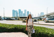 Czy Dubaj jest bezpieczny dla kobiet podróżujących solo? Praktyczne wskazówki Stylowa kobieta idąca ulicą Dubaju na tle miejskiej panoramy